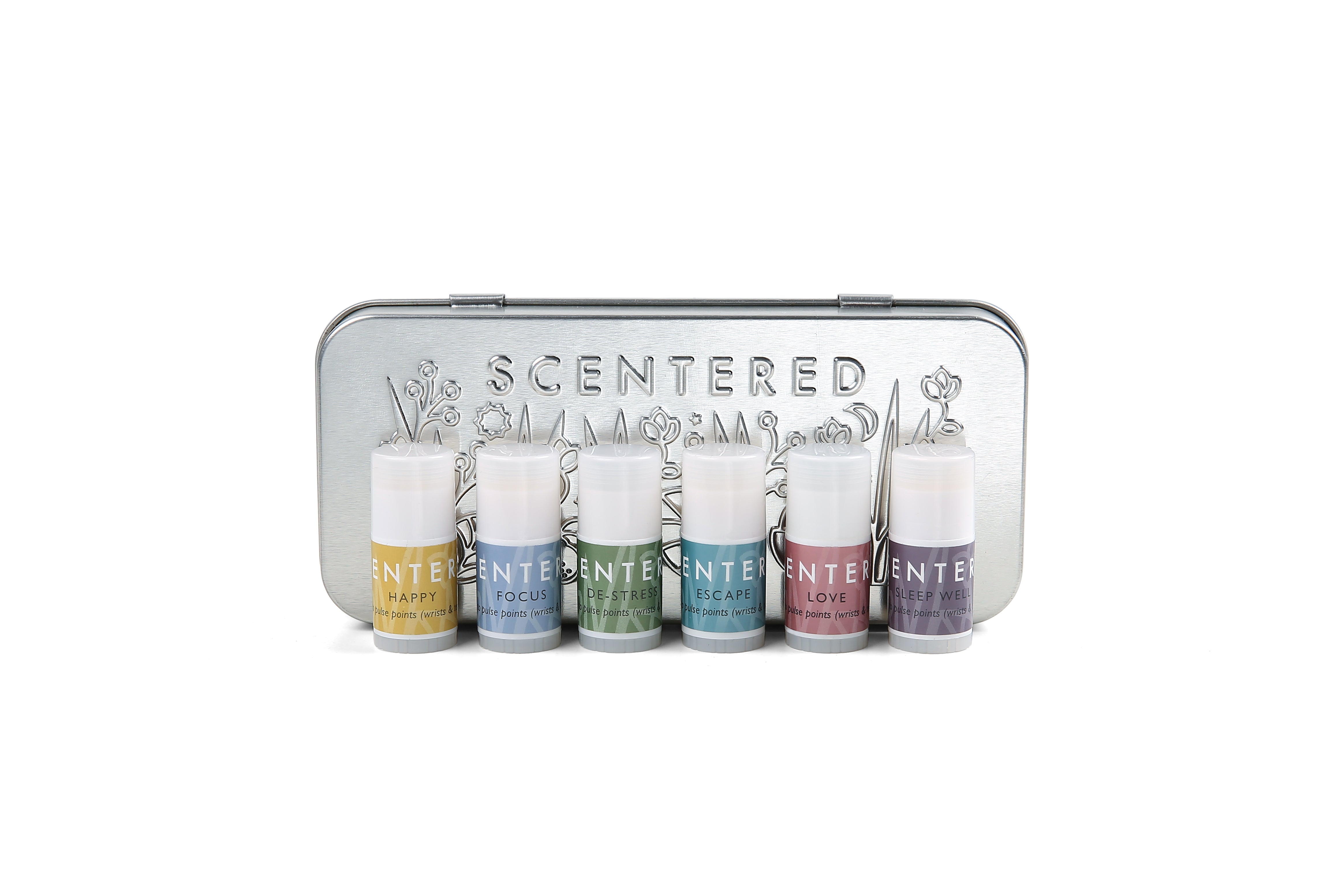 Scentered Aromatherapy Discovery Tin Set closed showing Scentered brand name on front of tin and embossed floral pattern.  In front of the tin  are the 6 aromatherapy balms included in the gift set: Happy, Focus, De-stress, escape, Love and Sleep Well Aromatherapy Mini Pulse point balm sticks 1.5g