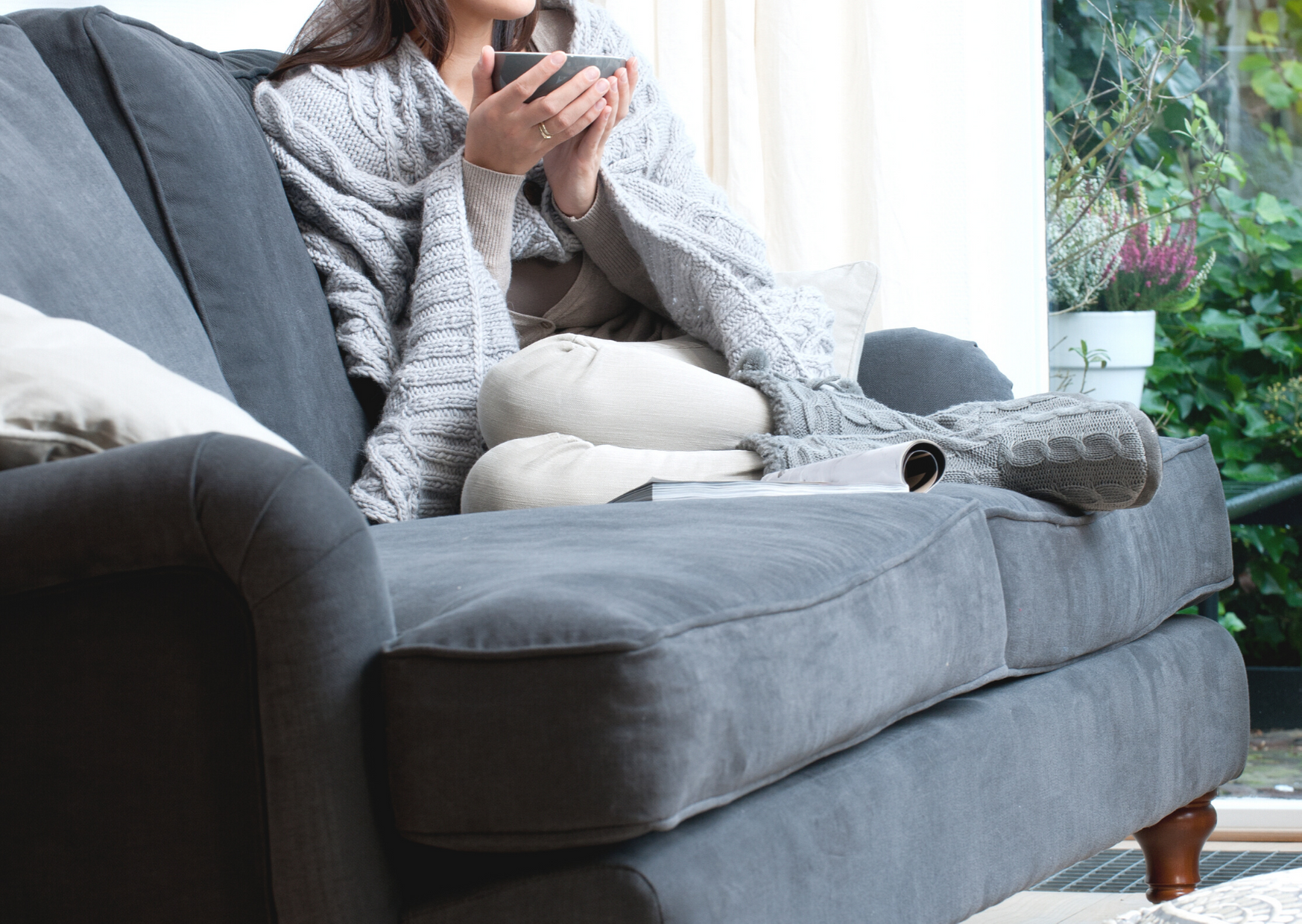woman having tea in a cozy sofa