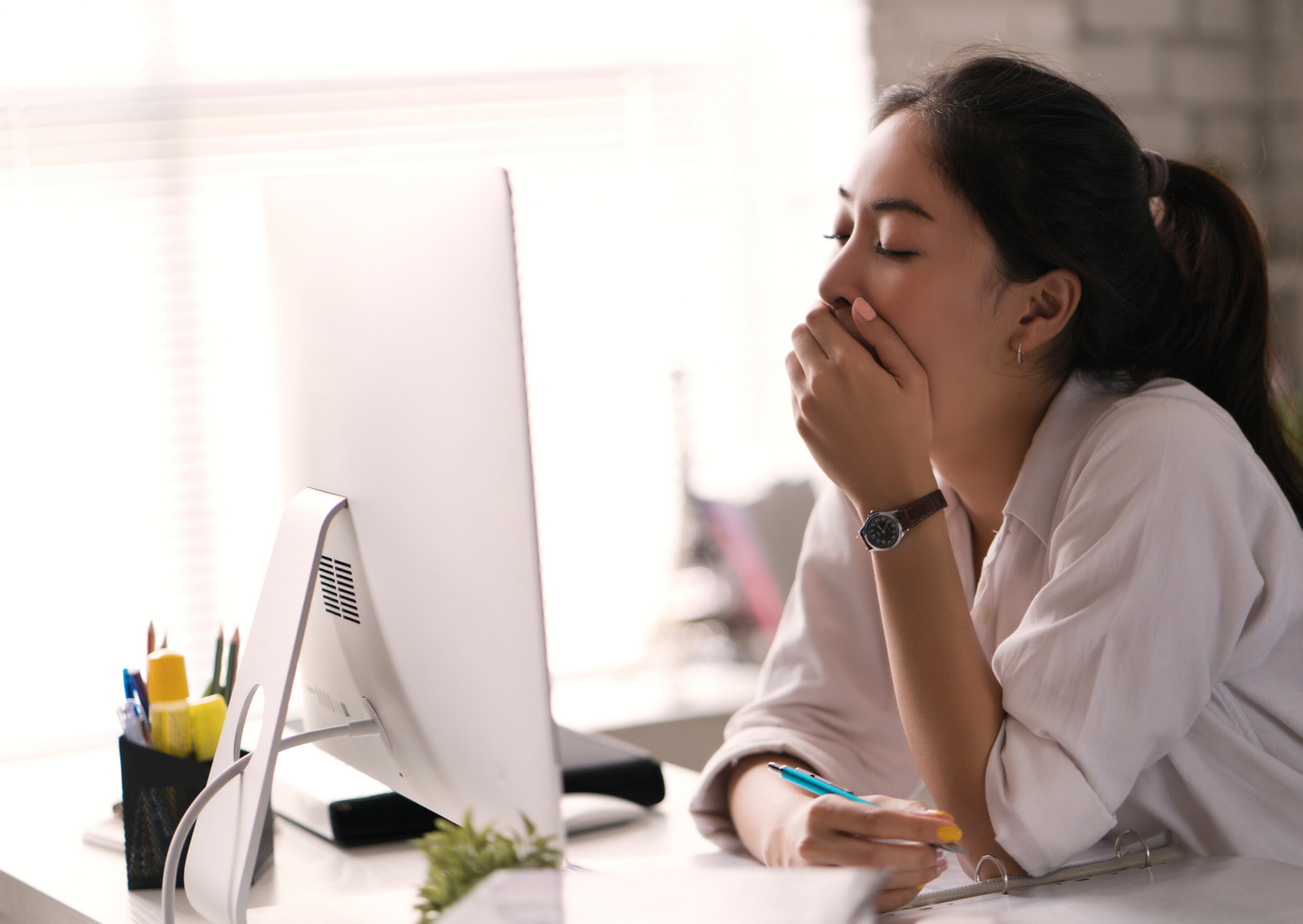 woman yawning in front of the computer