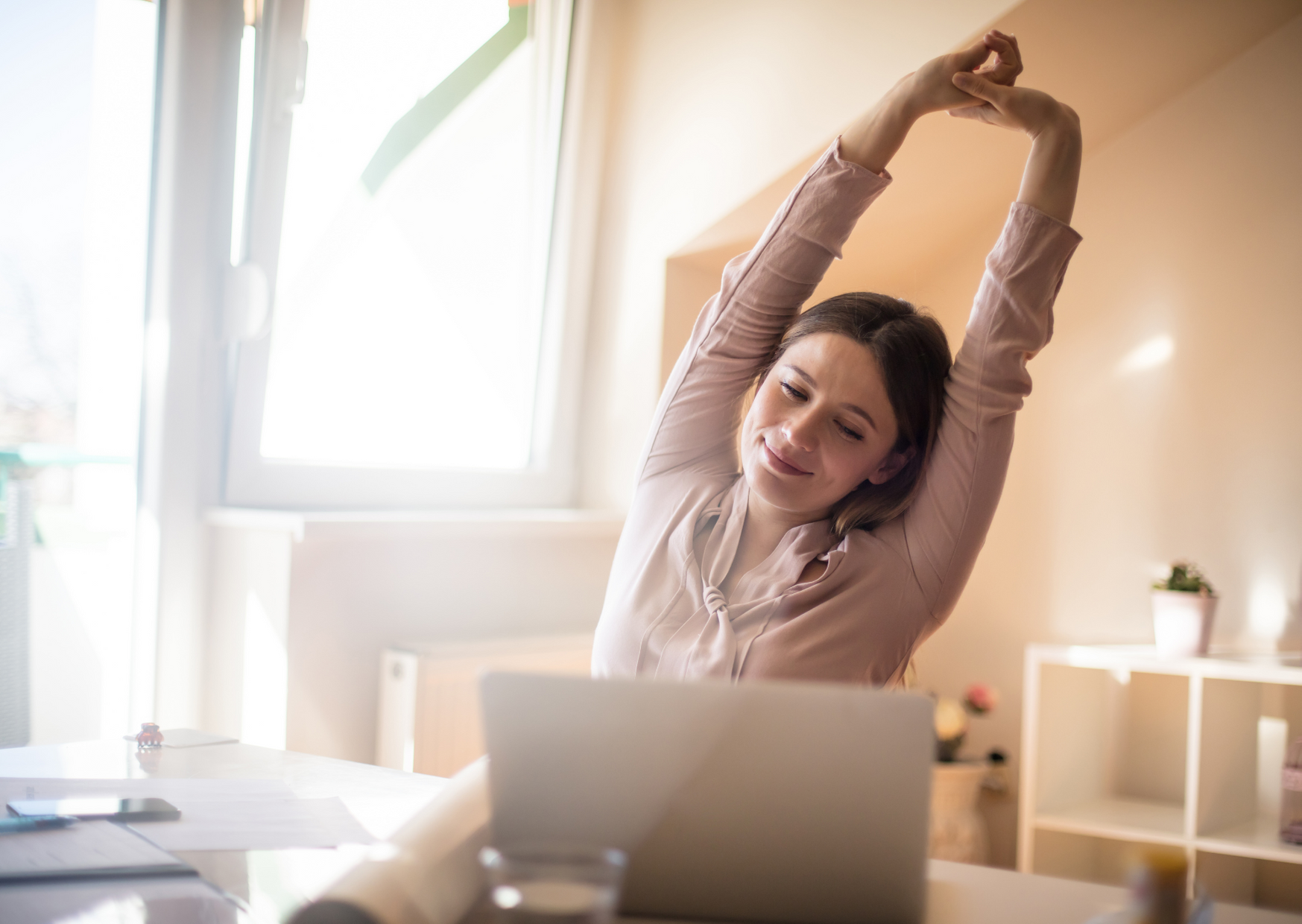 woman stretching in front of her laptop