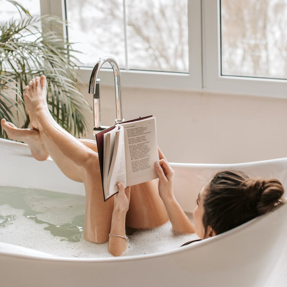 woman reading a book in the tub
