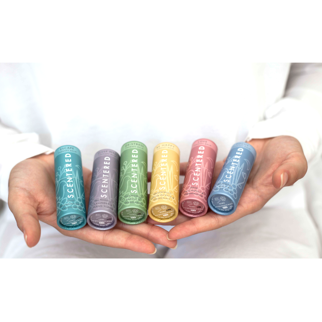 All of the six Scentered Aromatherapy Balms in a woman's hands, resigned to helping sleep, calming, relaxtion, happy